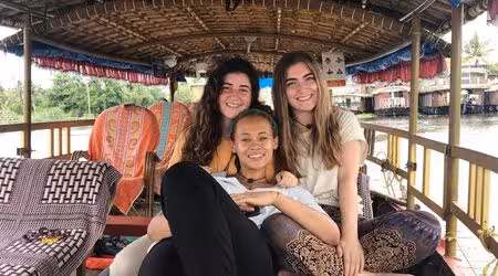 An excursion in Shikara boat in Alleppey - Traditional Shikara boat gliding on the serene backwaters of Alleppey, surrounded by lush greenery and calm waters.