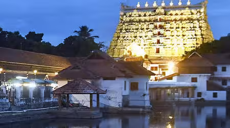 View of the majestic Sree Padmanabhaswamy Temple in Thiruvananthapuram, Kerala, featuring its intricate Dravidian-style architecture and iconic gopuram reflecting in a serene temple pond.