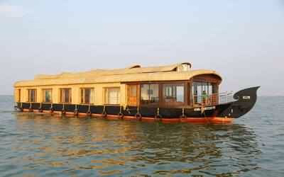 5-day Kerala Tours - Houseboat gliding through the serene backwaters of Alleppey, Kerala, surrounded by lush greenery