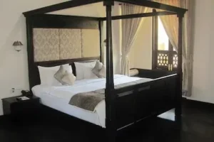 Comfortable bedroom at Green Wood Resort in Thekkady surrounded by lush greenery, featured in 4-day Kerala tour packages, Kerala, India.